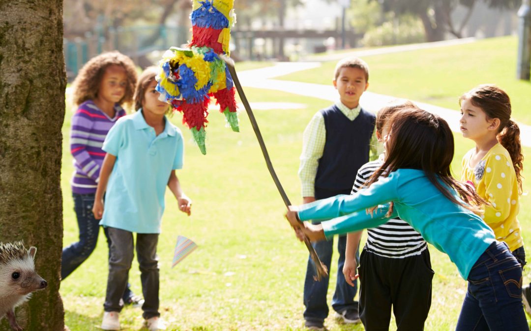 Party Without Plastic: children hitting a paper piñata with a hedgehog looking on curiously